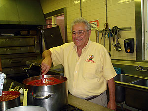Photo of Nicholas Caggiano, Sr. of Nicola Pizza cooking in his restaurant's kitchen